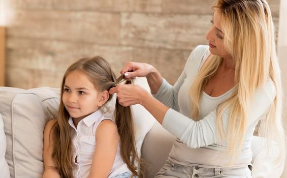 phot of a woman braiding a little girl's hair